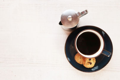 コーヒーのポットとカップ。チョコチップクッキーが添えられている。