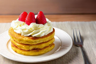生クリームといちごがのったパンケーキのお皿。