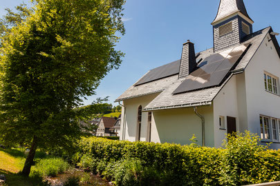Außenansicht des Ferienhauses "Kleine Kapelle" in Netphen mit Grün drumherum und blauem Himmel
