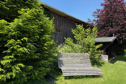 Garten mit Bank auf einer Wiese hinter dem Ferienhaus