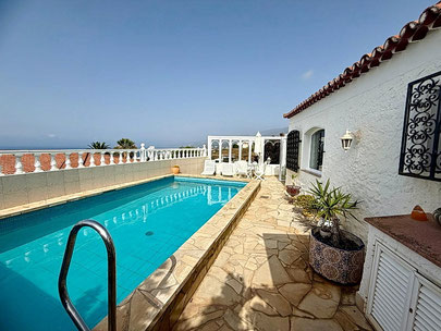 Terrasse am Haus mit kleinen Garten und Blick auf das Meer.