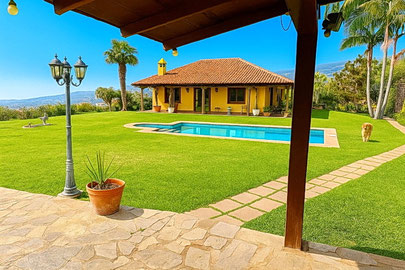 Terrasse am Haus mit kleinen Garten und Blick auf das Meer.