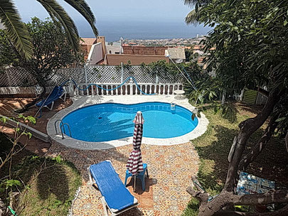 Blick auf den hauseigenen achtförmigen Pool von dem Balkon des Hauses.