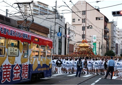 夕刻の鳥居前で神輿を回す