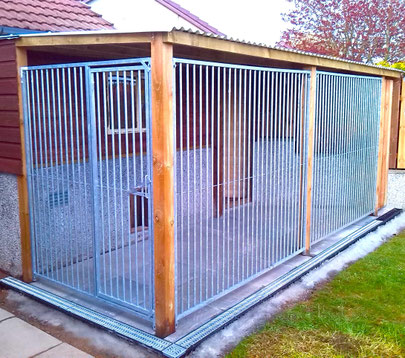 Brick and wood shed with attached dog kennel run, concrete slab flooring, and corrugated roof.