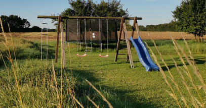 Spielbereich für die Kinder-großes Trampolin, Rutsche, Schaukel
