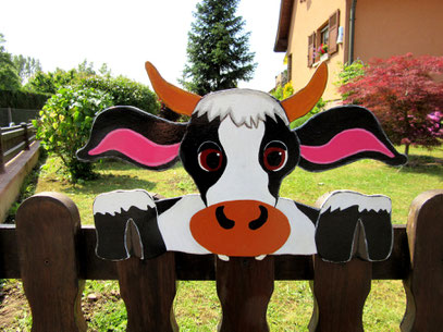 Vache en bois dans son jardin 