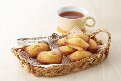 フィナンシェが盛り付けられたかごと紅茶のカップ。