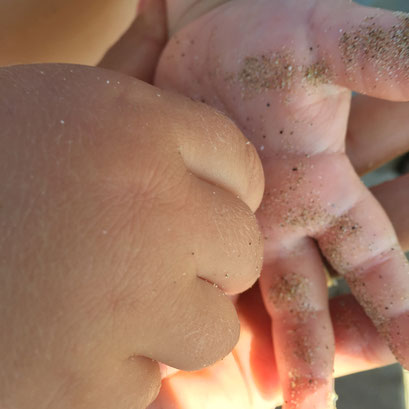 Kinderhände mit Sand beschmiert