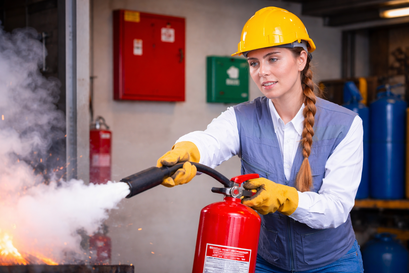 Brandschutzhelferin mit Feuerlöscher im Betrieb, Brandschutzhelferschulung, Brandschutzhelfer Kurs, Feuer im Betrieb