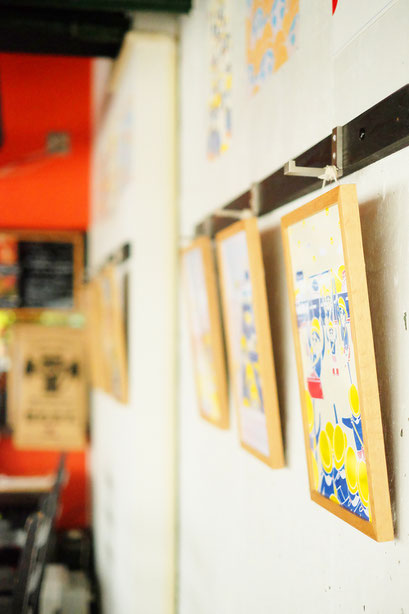 広島のイラストレーター、絵本作家、ミヤタタカシの絵本と絵の展示風景「カフェマルティッド」壁面にて