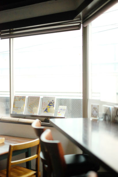広島のイラストレーター、絵本作家、ミヤタタカシの絵本と絵の展示風景「カフェマルティッド」窓際にて