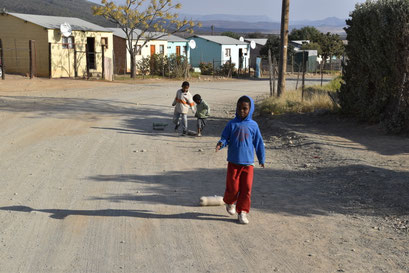 Tevreden met een lege fles als speelgoed, Township tour in Umasizake (Graaff Reinet), Zuid Afrika (2018)