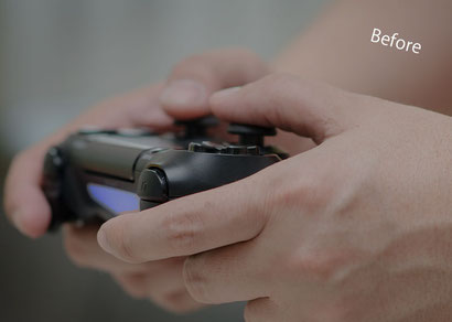 ゲームコントローラーを持つ少年の手