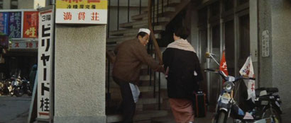 ▲階段を上る久造。「満貫荘」はどうやら2階にあるようだ。(画像③)
