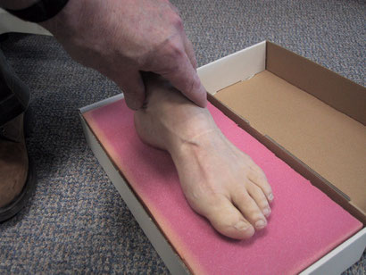 demonstrating how an imoression is taken of the foot