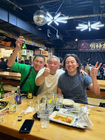 ひろめ市場にて男性3人がお酒を片手に楽しむ
