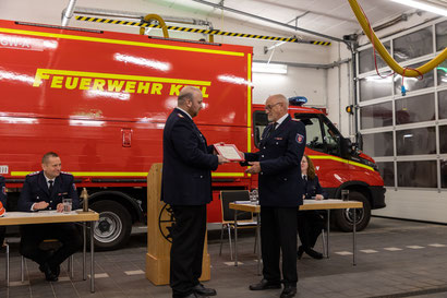 Wolfgang Dörfler (re.) erhält zur Übernahme in die Ehrenabteilung, sein Original Aufnahmegesuch in die Jugendfeuerwehr Wellsee aus dem Jahre 1968 von Björn Reimer.