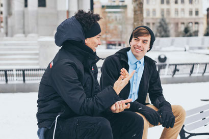 Two young men speaking to each other. Learning to listen mindfully in a conversation is an important skill to learn.