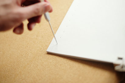 広島のイラストレーター、絵本作家の手製本で絵本を作る写真。鋭い針で穴を開ける。