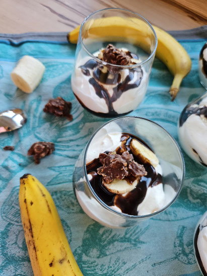 Banana Split Dessert im Glas mit Bananen und Schokoladensauce 