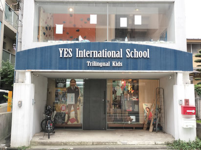 YESの外観。青の湾曲した看板に「YES International School」と書いてある。