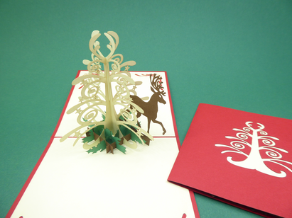 Carte de Noël en pop-up cerf près d'un sapin