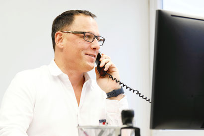 Geschäftsführer am telefonieren vor dem Monitor