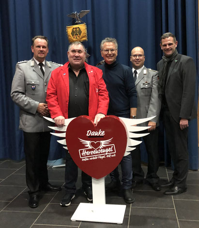 Foto: v.l.n.r.: Dirigent Hauptmann Holger Kolodziej; Vorsitzender des Herzensengel e.V. Adrian Schmitz; Überraschungsgast Michael Friemel; Organisator Musikkorps Oberstabsfeldwebel Marc Weber; Beiratsvorsitzender Mettlach & Bürgermeister Daniel Kiefer
