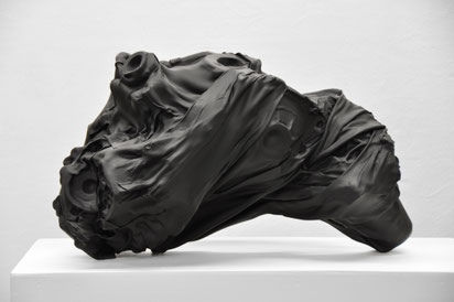 zeitgenössische Skulptur von Andreas Jonak, schwarze Faltenwurf bildende sich stretchende und bewegende Form, sich durchdrückende mechanische Getriebeteile