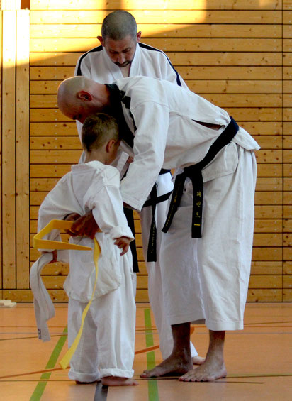 Das Anlegen des gelben Gürtels, nach bestandener Taekwon-Do prüfung von Trainer Zoltan Cisar und Großmeisters Hannes Hintermayr