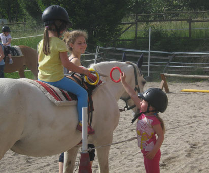 Miniclub beim spielerischen Reiten auf dem Reitplatz