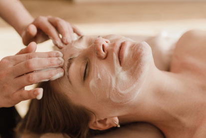 Femme qui se détend en institut de beauté, a qui on fait un nettoyage de peau 