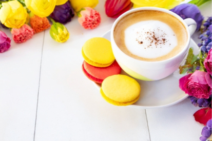 カラフルなマカロンが添えられたカプチーノ。色とりどりのバラの花たち。