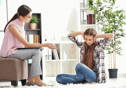 Ein Mädchen im Teenageralter hält sich die Ohren zu, während die Mutter Ihr etwas erklären möchte.
