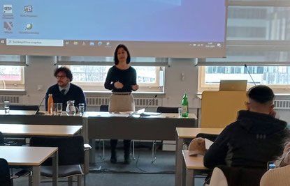 Teilnehmer:innen hören Präsentation zu