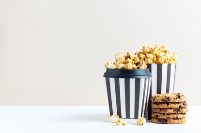 テイクアウトコーヒーとポップコーンのカップ、チョコチップクッキー。