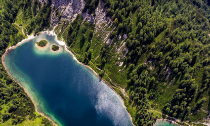 Luftaufnahme vom Steirersee auf der Tauplitzalm mit Almwegen im steirischen Salzkammergut