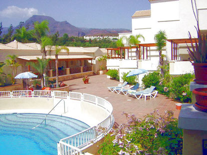 Blick auf den Gemeinschaftspool mit großer Terrasse zum Sonnen.