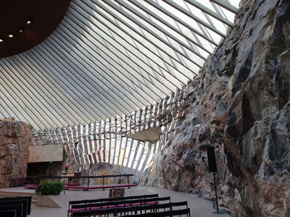 Felsenkirche Temppeliaukio mit roher Felswand im unteren Teil und luftigem Glasdach oben. Das Licht wird durch die Lamellen des Dachs gebrochen. ©My own Travel - Südfinnland und Tallinn-Rundreise mit My own Travel