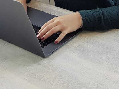 Zu sehen ist ein Laptop und 2 Hände, die etwas auf der Tastatur eingeben. Kontakt - Textzauberin Anika Büchner - Texterin Brandenburg