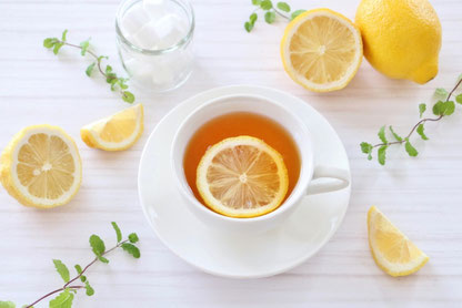 レモンの輪切りが浮かべられた紅茶のカップ。傍らにレモンと角砂糖の瓶。