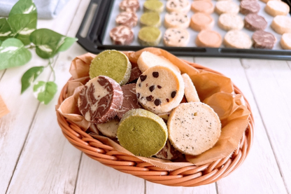 籐のかごにいっぱい盛り付けられたアイスボックスクッキー。天板に焼きたてのクッキーが並んでいる。
