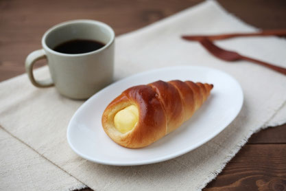 クリームコルネのお皿とコーヒーの入ったマグカップ。
