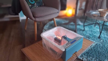 Body Detox Elektrolyse Fussbad vor grauem Sessel mit Licht im Wasser, www.passion-of-nature.ch