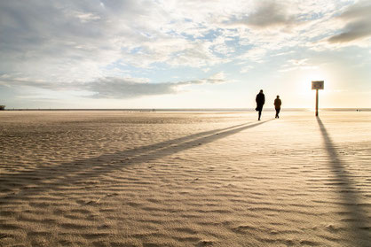 zwei Personen beim Strandspaziergang