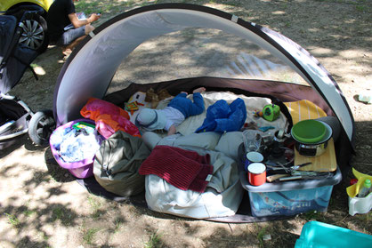 Baby in Strandmuschel auf Campingplatz.