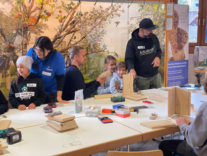Die Kinder vom SkateboardNest werkeln mit Tamara Ayoub (li.) und Ado de Melo (re.) im NABU-Vogelschutzzentrum. - Foto: U. Klobe de Melo