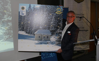 Zehn Jahre Adventskalender der Lions Clubs Schwenningen und Villingen bringen 300.000,- Euro für soziale Zwecke ein. Bei der Jubiläumsfeier präsentiert der Projektinitiator Hansjörg Zimmermann das Kalendercover 2018. Bild: Alexander Hämmerling