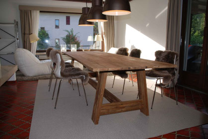 Kaminzimmer mit großem Teaktisch, Loungern und Lammfellen auf den Stühlen